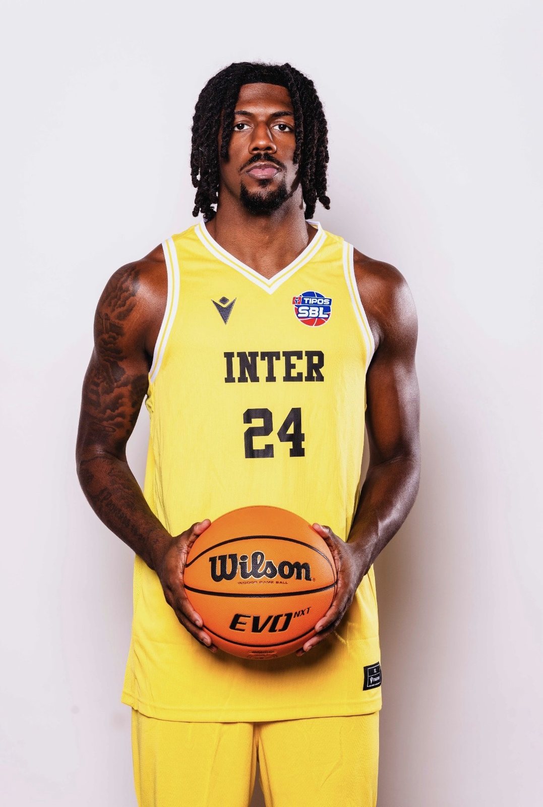 Nehemiah Benson holding basketball in yellow jersey