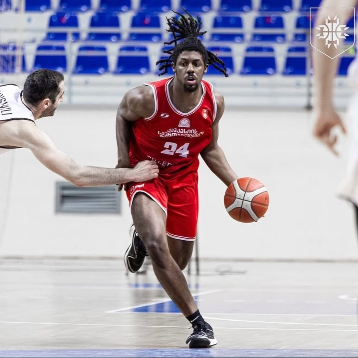 Nehemiah Benson dribbling in red uniform